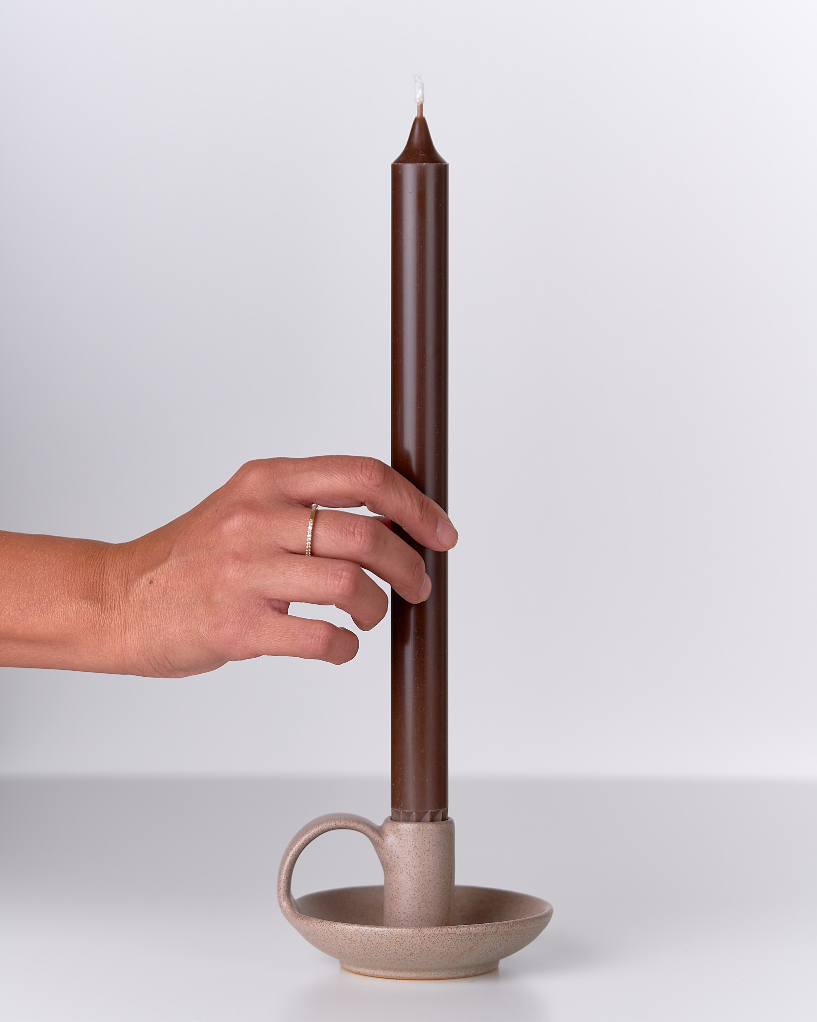 Porta candela in ceramica con candela, luce calda e atmosfera rilassante.