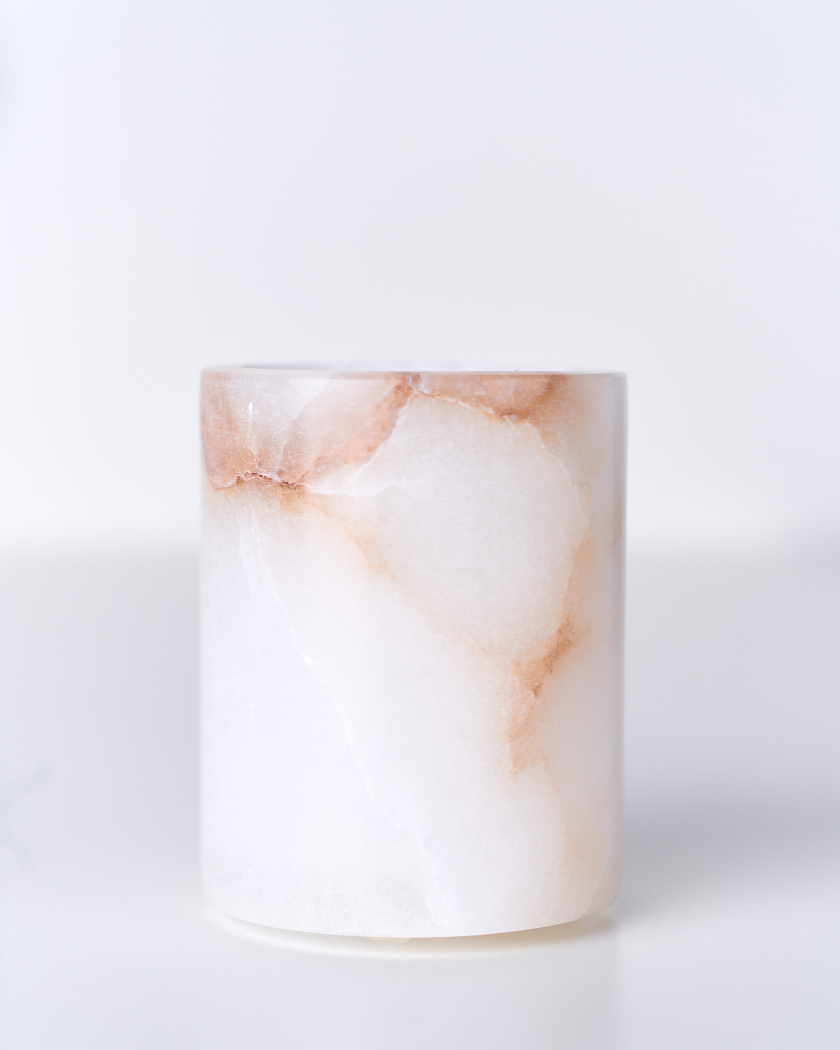 Porta candele in alabastro naturale, superficie levigata e luce calda diffusa, Terracotta Home Store.