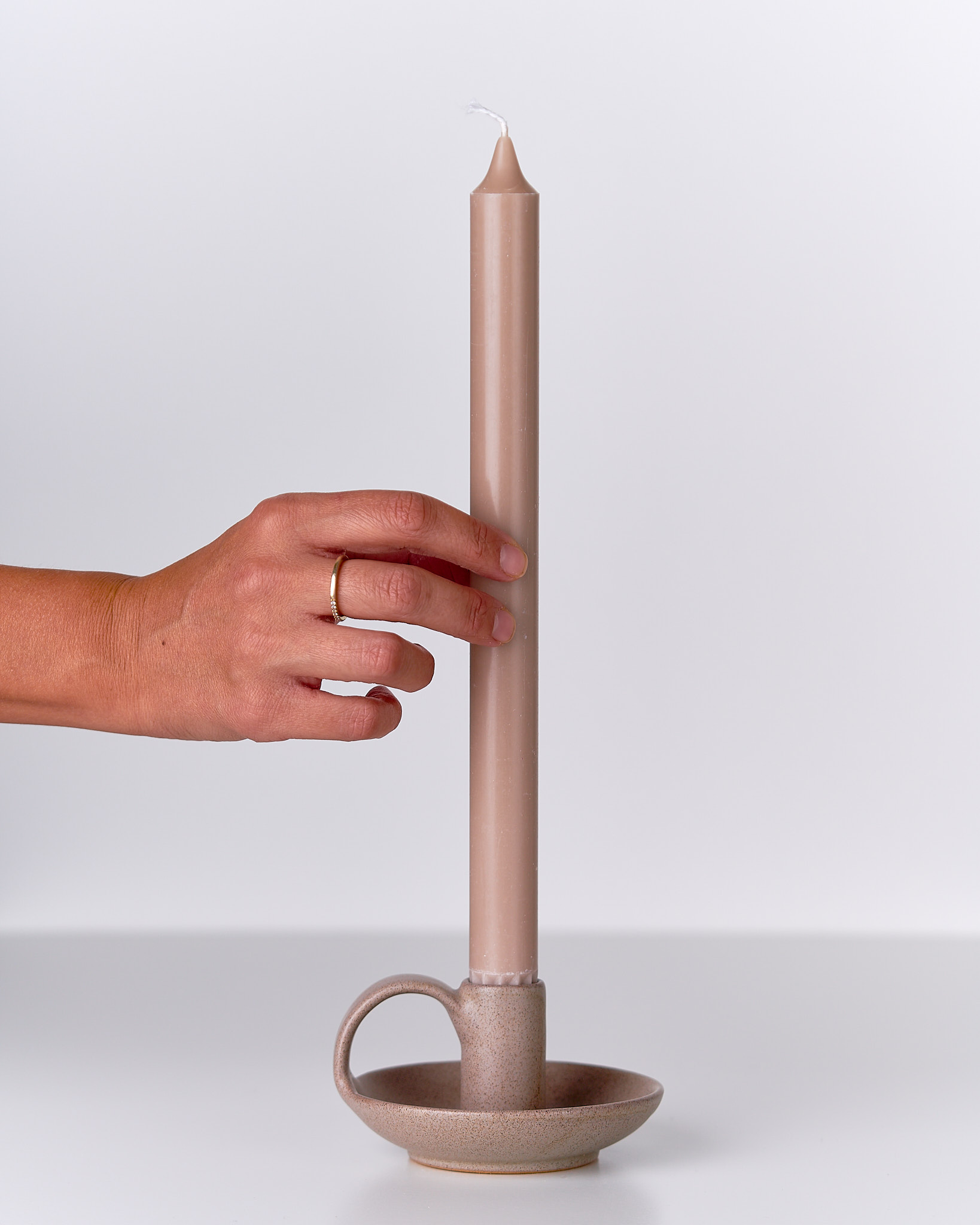 Porta candela in ceramica con candela, luce calda e atmosfera rilassante.