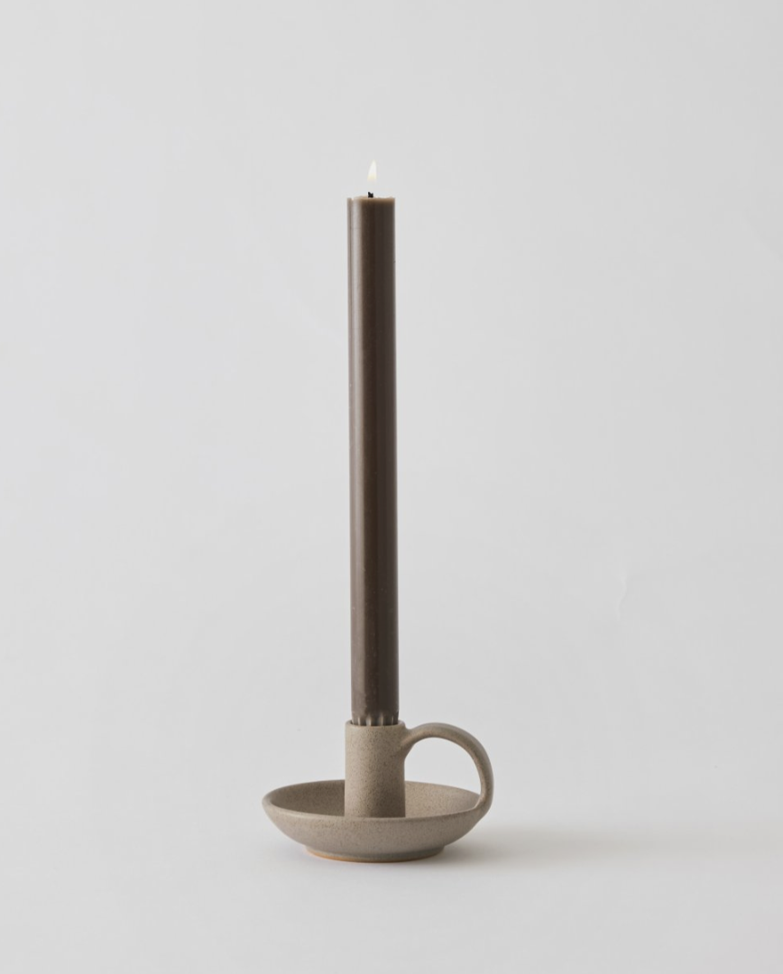 Porta candela in ceramica con candela, luce calda e atmosfera rilassante.
