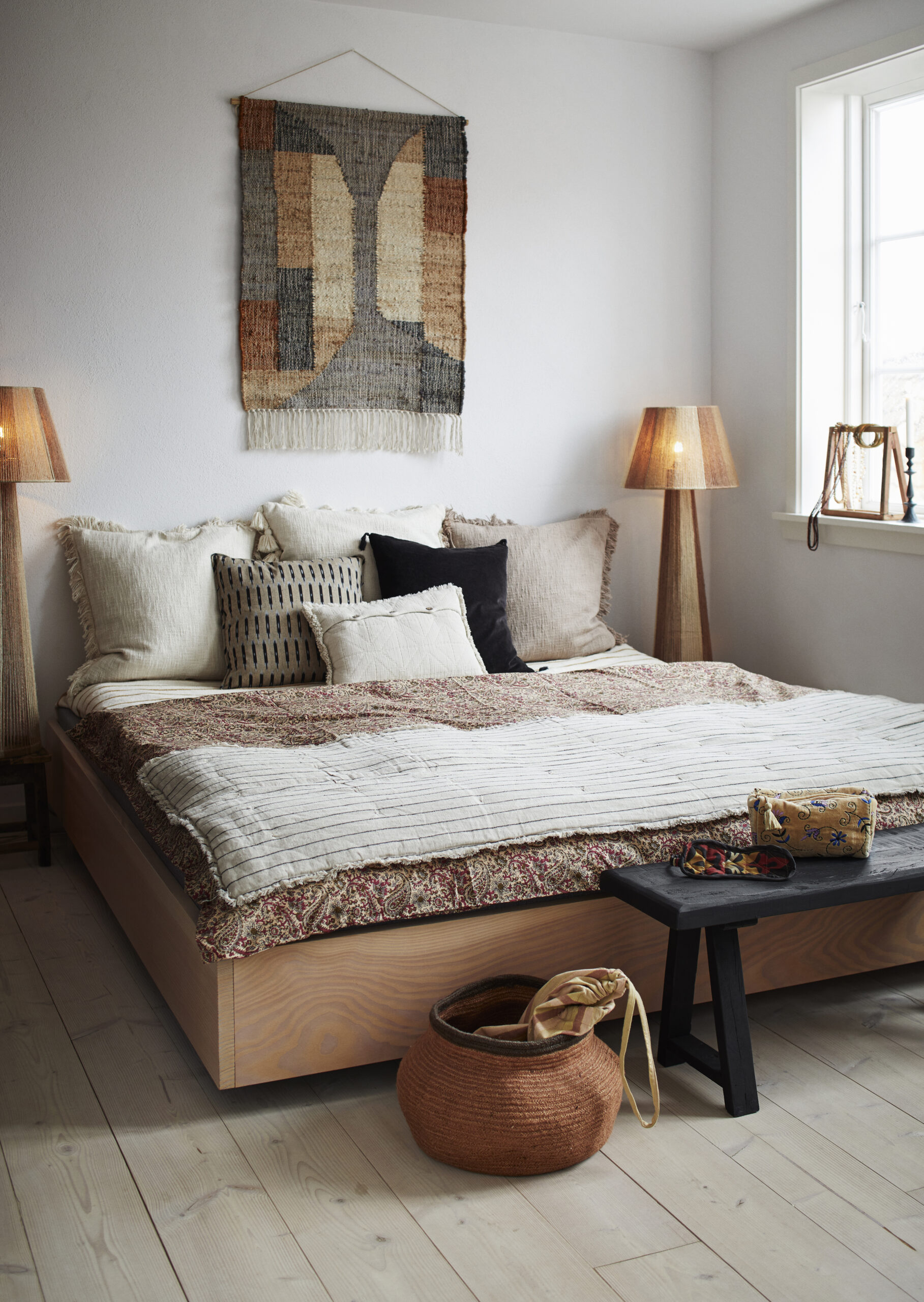 letto con cuscini naturali ambientati in stanza boho